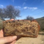 Banana bread with sunny hill and dirt trail in the background.